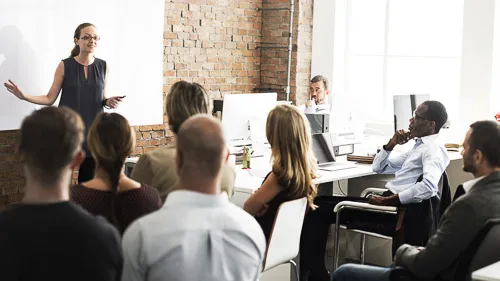 A woman leads a presentation in front of a group