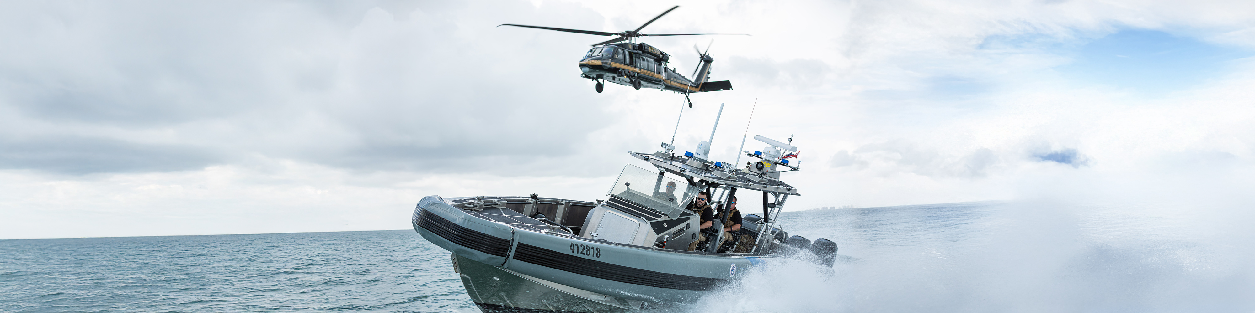 Air and Marine Operations UH-60 Black Hawk helicopter flies over a Coastal Interceptor Vessel