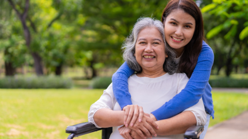 Caregiver or nurse taking care of the patient in a wheelchair.