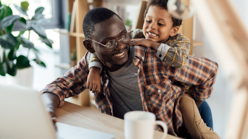 Father spending time with son and working with laptop