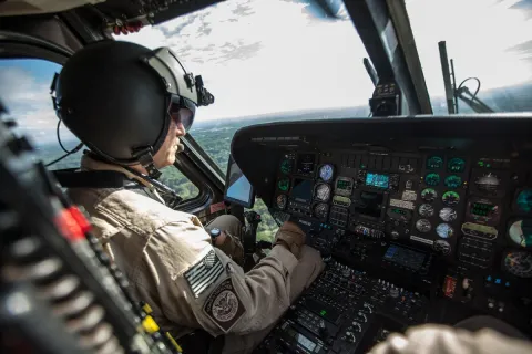 A CBP Air Interdiction Agent patrols in a Black Hawk helicopter.